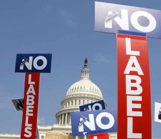 FILE - People with the group No Labels hold signs during a July 13, 2013, rally on Capitol Hill in Washington.